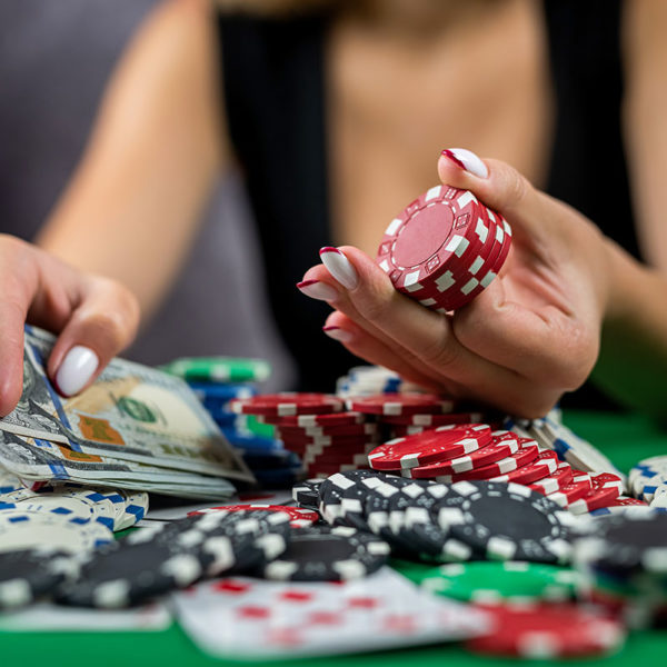 female-player-counts-chips-money-raises-bet-while-playing-poker-casino